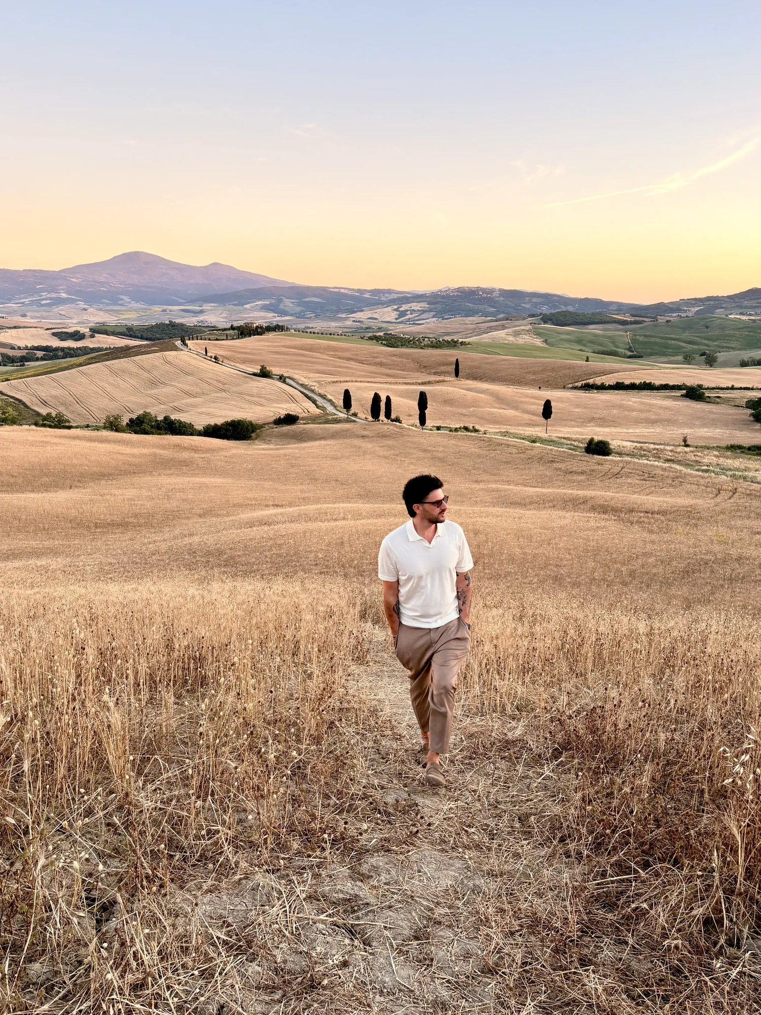 Daniele Antoniol walking through the Tuscan countryside at sunset