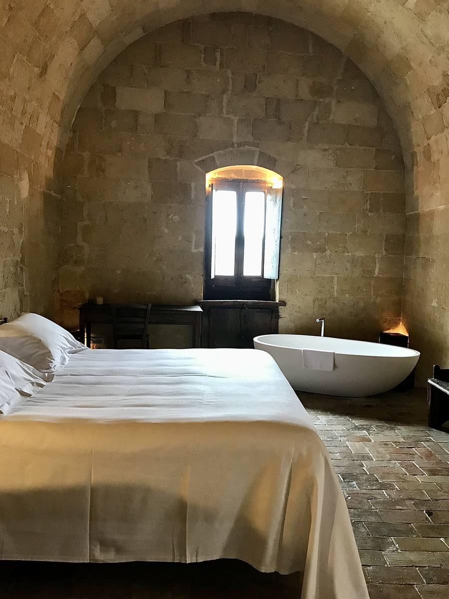 A stone room with a minimalist bathtub at Sextantio in Matera